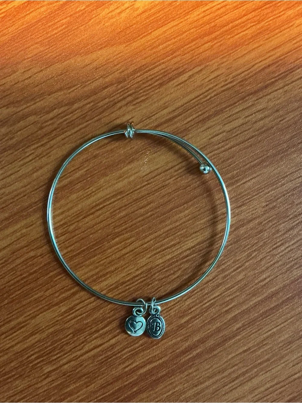 A Brighton silver tone bangle and a no brand bangle with heart shape charm.